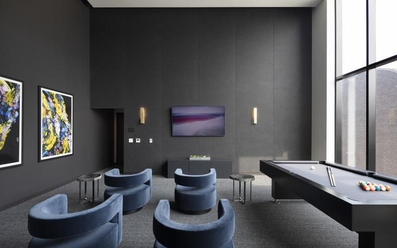 a room with a pool table and chairs